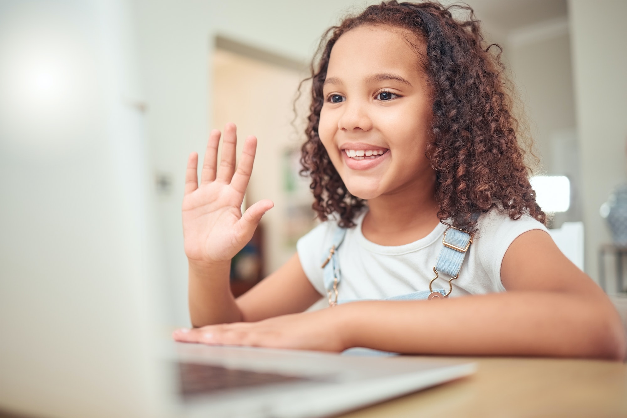 Elearning, video call and child with laptop in online class wave hello for learning, education and